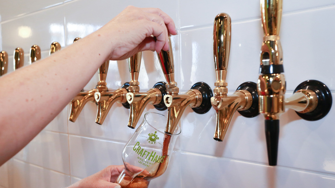 Beer being poured from a tap on the wall.