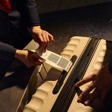 A label being attached to a suitcase by a British Airways staff member.
