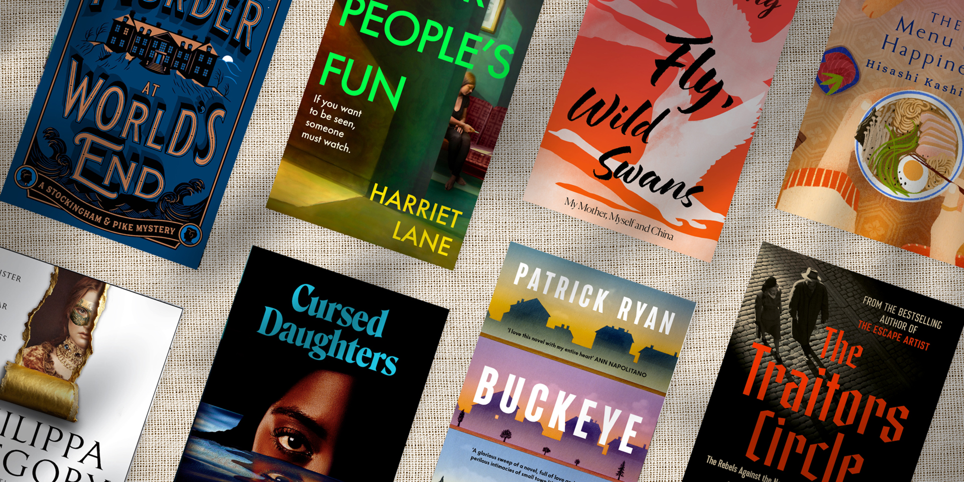 A collection of new books on a linen background.