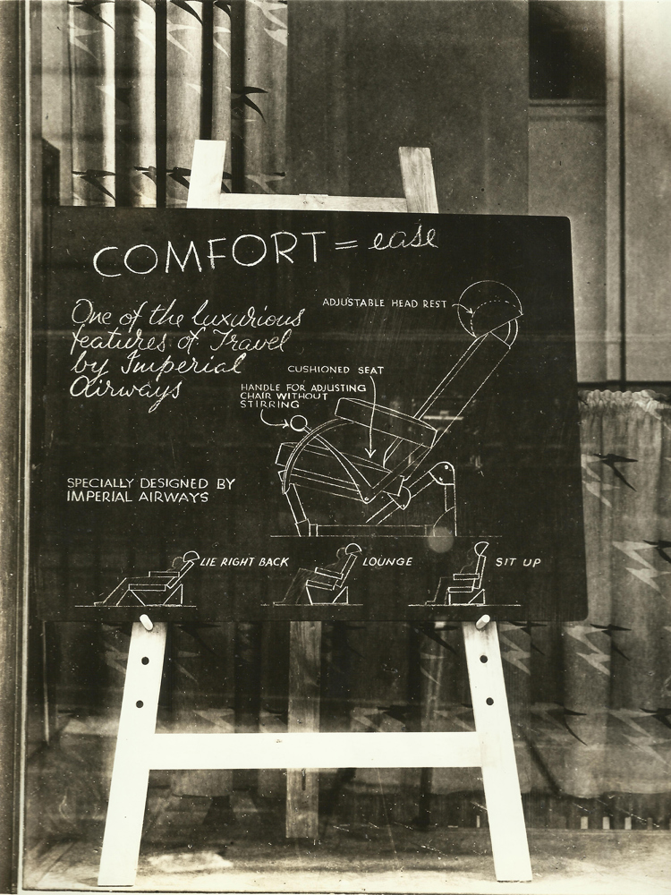 A blackboard with a drawing of an airplane seat on it.