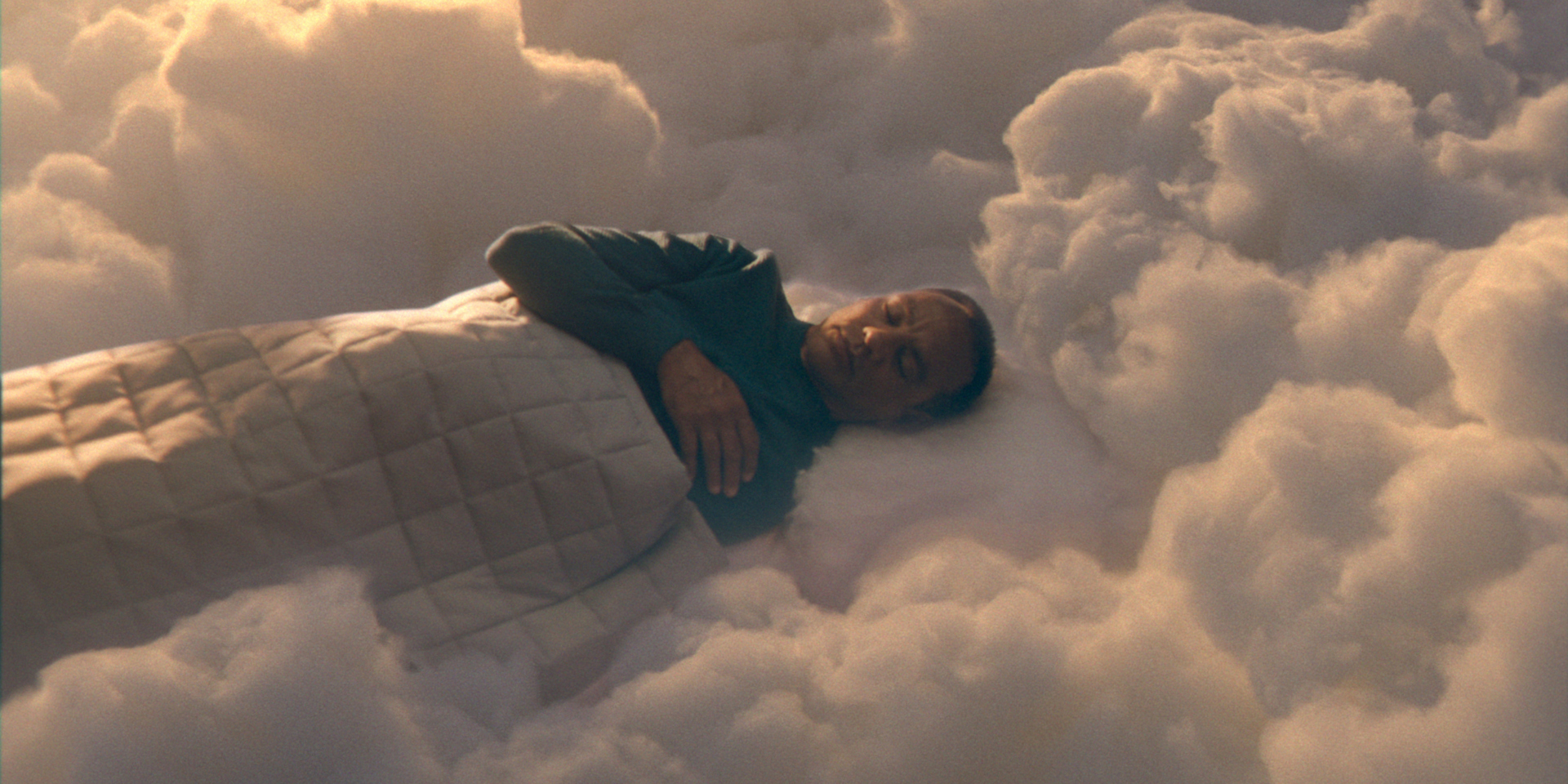 A still of a man sleeping among clouds from a British Airways advert.