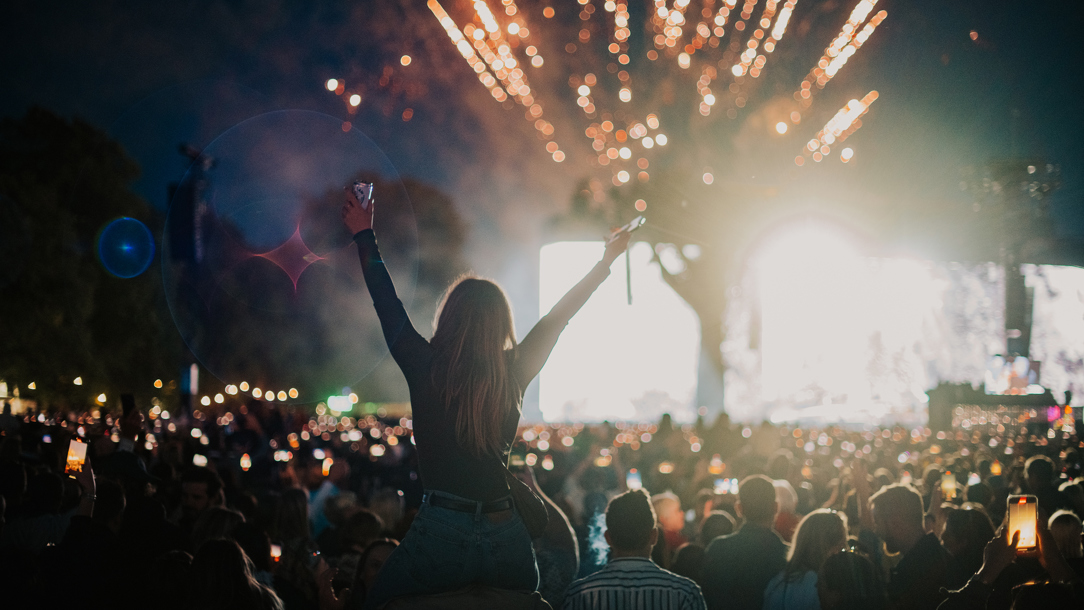 Fireworks at night and a crowd at a music festival.