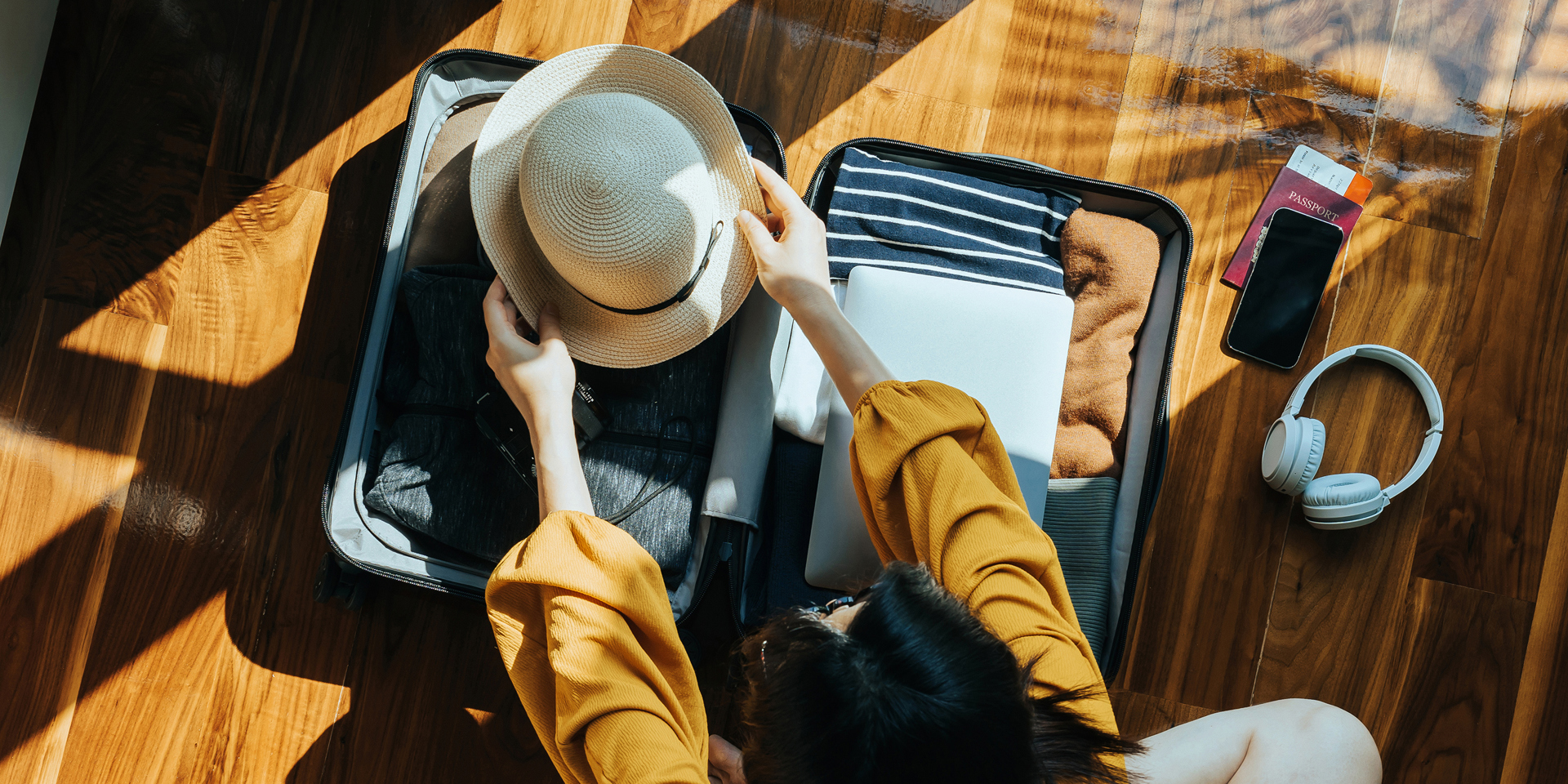 Overhead view of a woman packing a suit case.