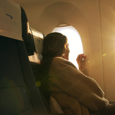 A lady looking out of the window on a British Airways flight.